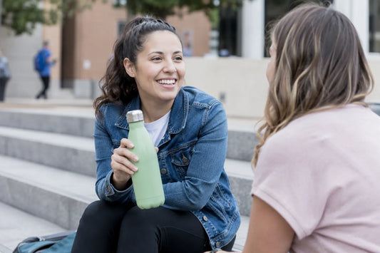 Woman holding water while spending time with friends after quitting smoking
